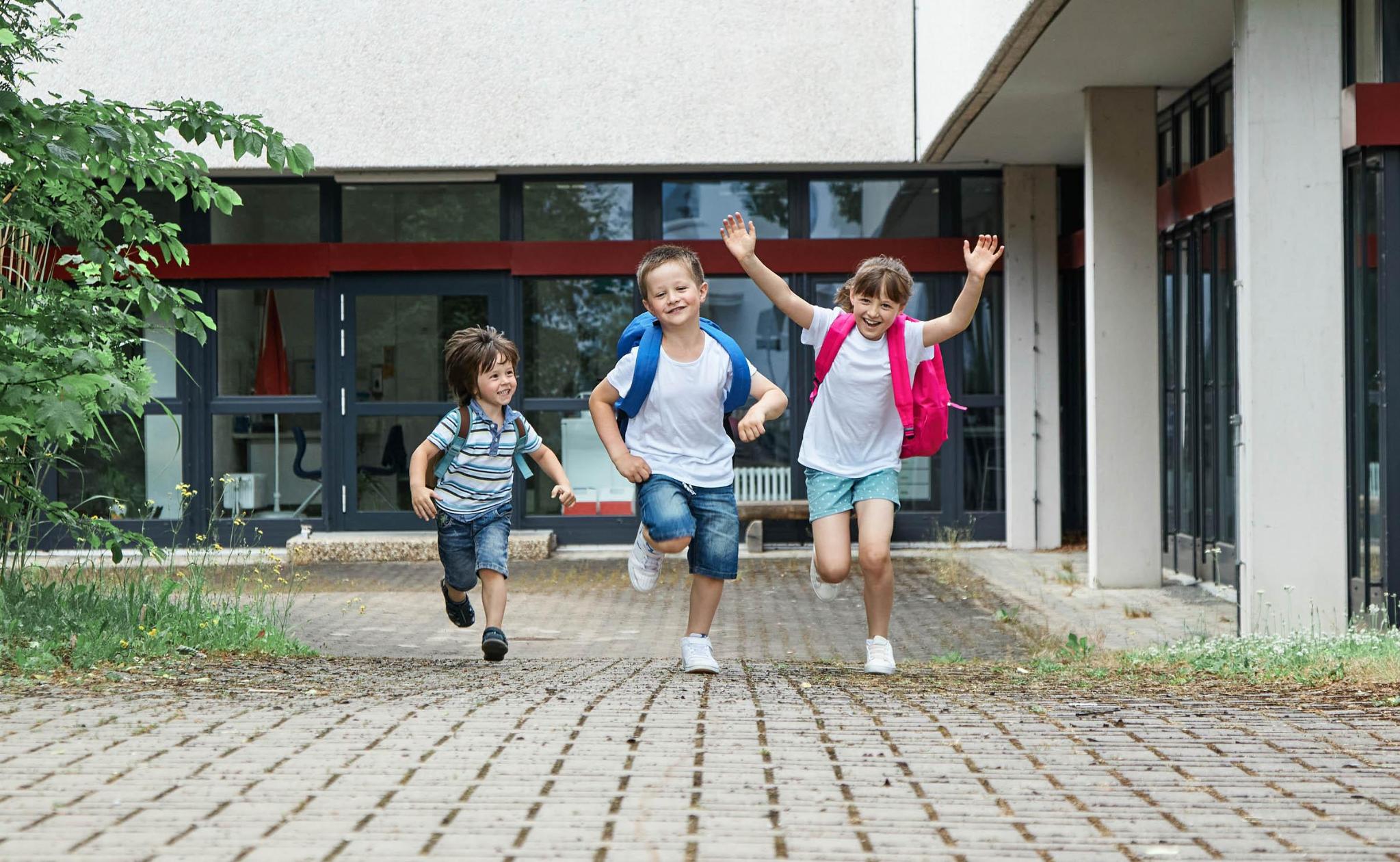 Three children excited to start school.